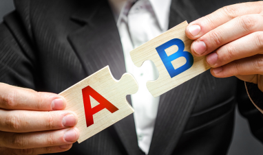 A B letters held by a person wearing a suit