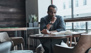 man sitting at table with book
