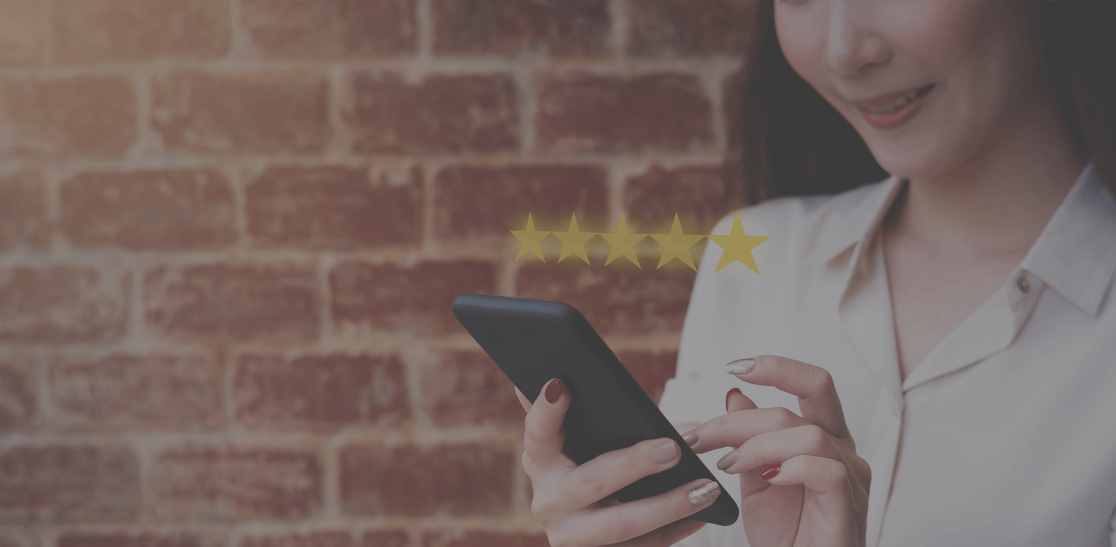 woman smiling at smartphone after receiving five star rating