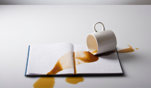 cup of coffee spilled over notebook
