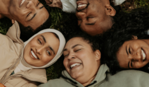diverse group of friends laying in a circle smiling