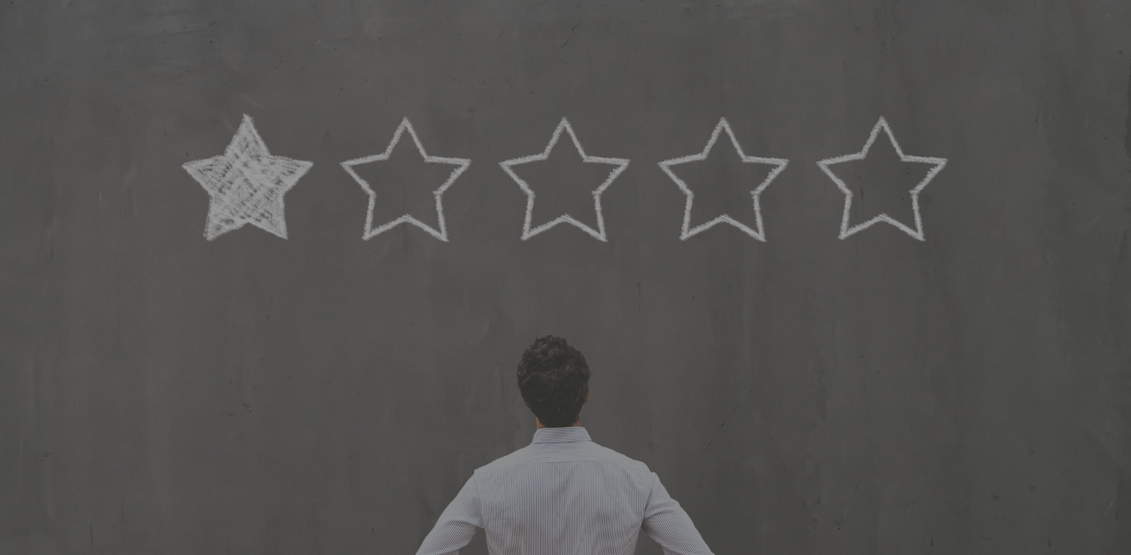 Man looking at one out of five stars on blackboard background
